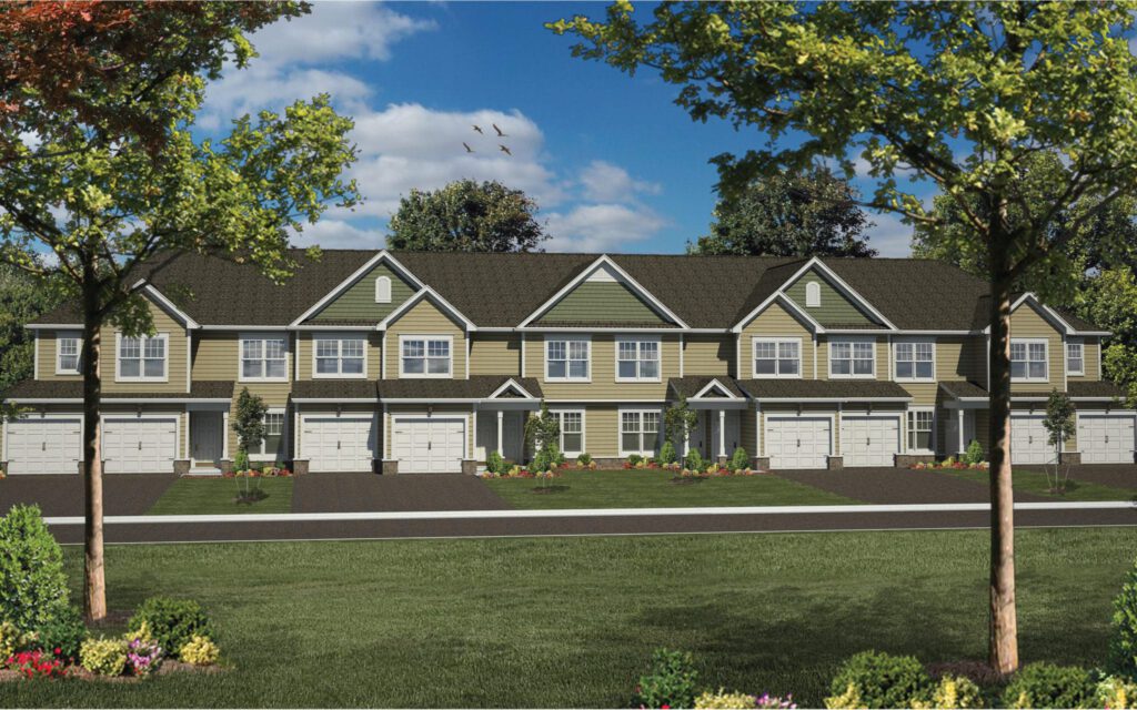 A row of modern townhouses with garages, surrounded by trees and grass under a clear blue sky.