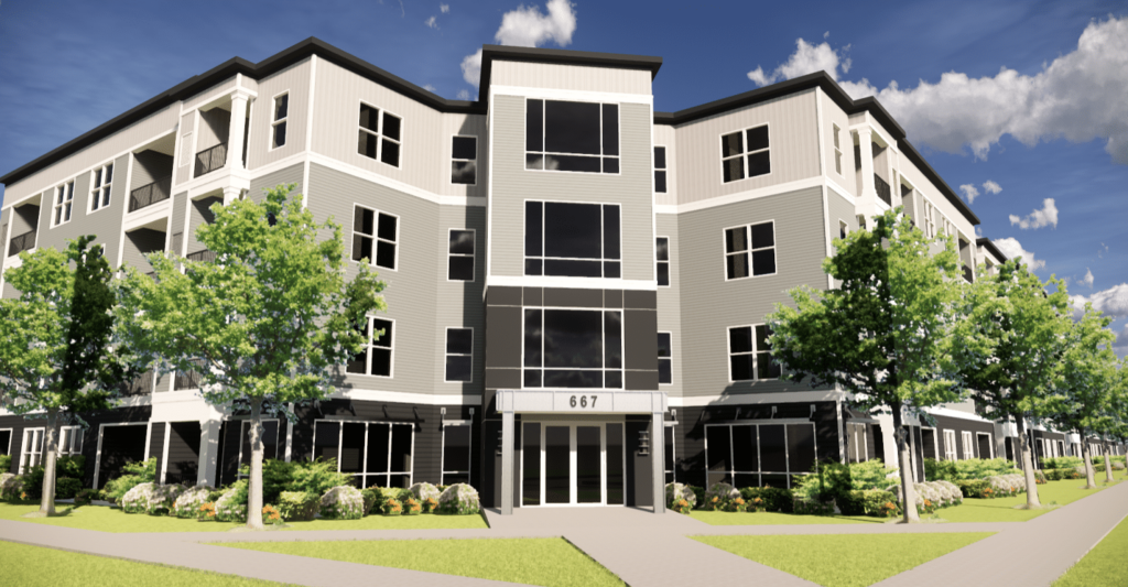 A four-story modern apartment building with large windows, surrounded by landscaped greenery and trees, under a blue sky with clouds.