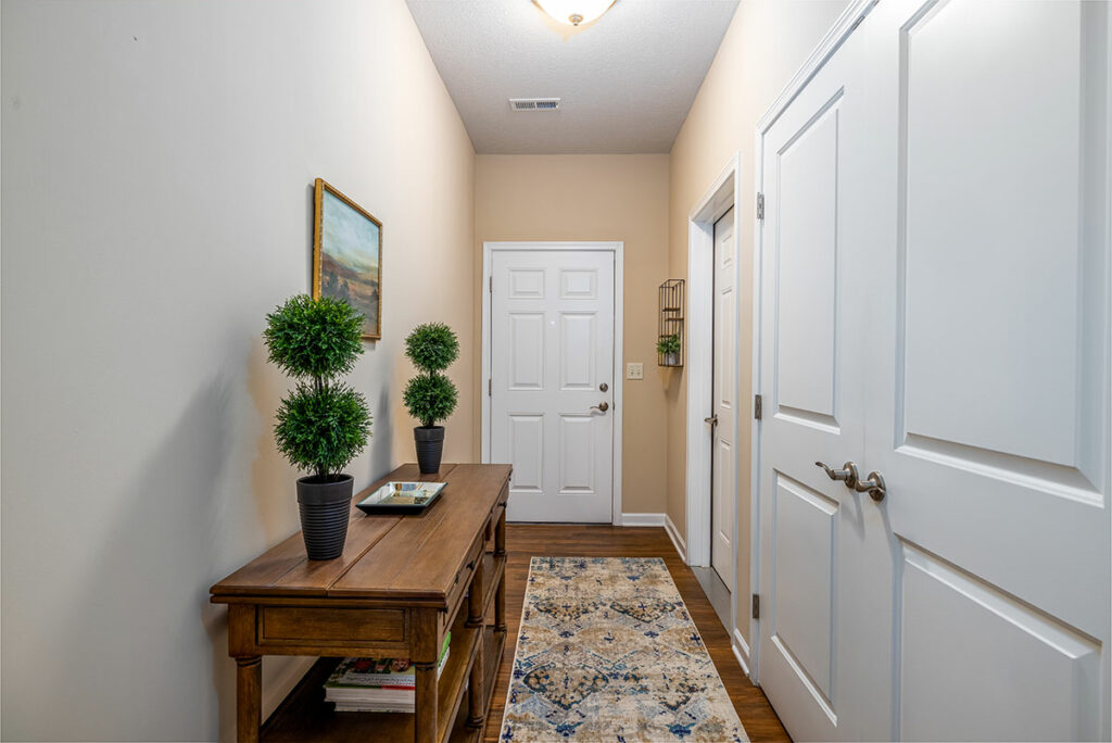 Spacious hallway entry in apartment model with doors to laundry room and garage