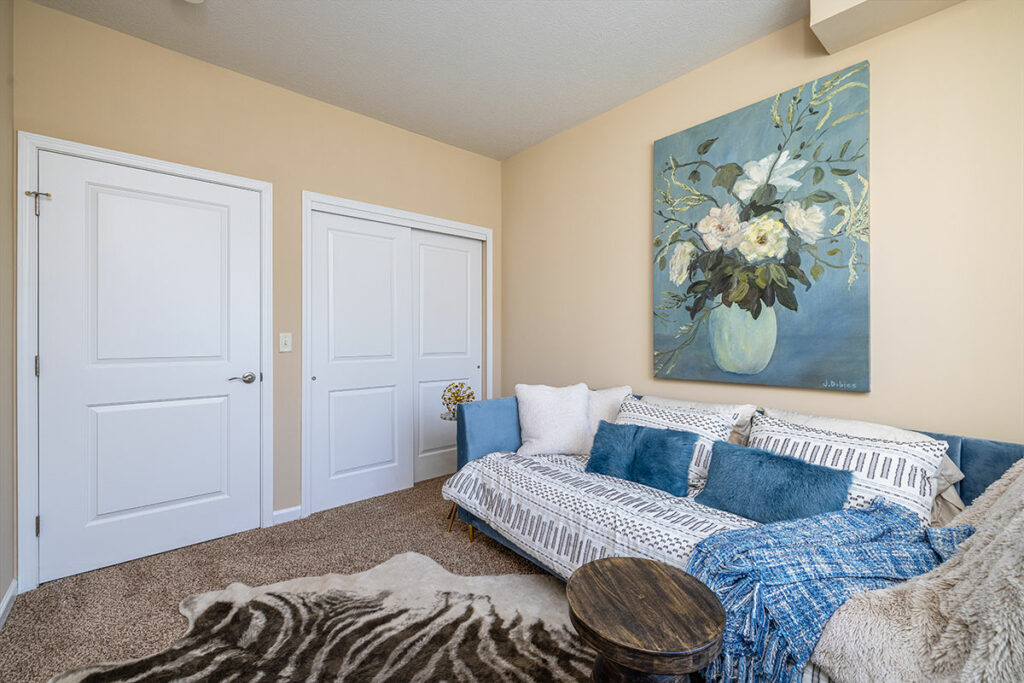 Spacious guest bedroom with carpeted floors and large closet space in apartment model