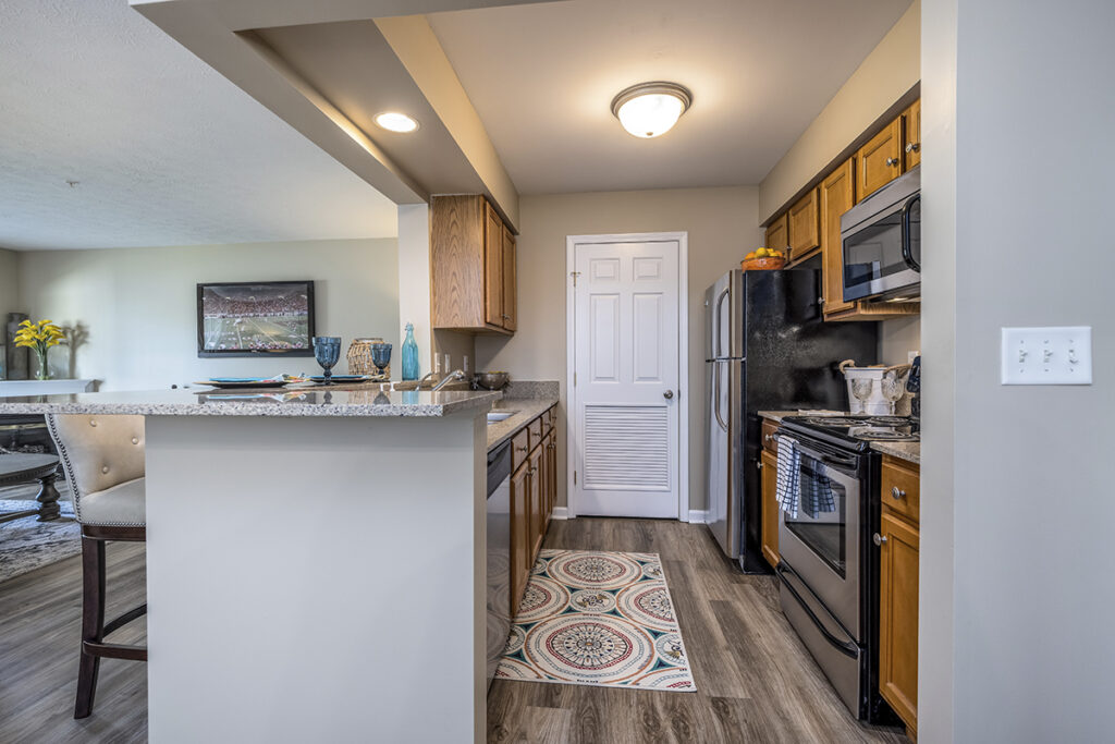 Bright kitchen featuring luxury vinyl plank flooring, stainless steel appliances, and elegant quartz countertops at The Hammocks at Orchard Park. A perfect blend of style and functionality.