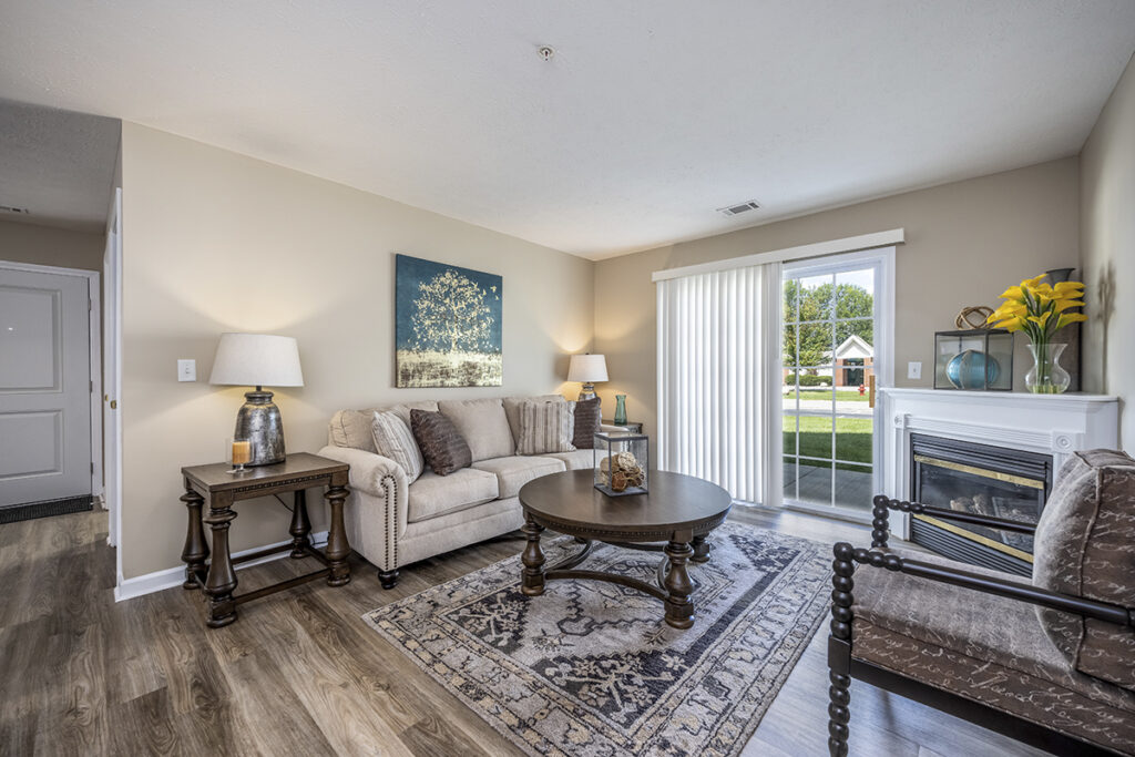 Renovated living room with LVP flooring, a cozy and inviting space designed for comfort and relaxation. Sliding glass door leads out to the first floor patio.