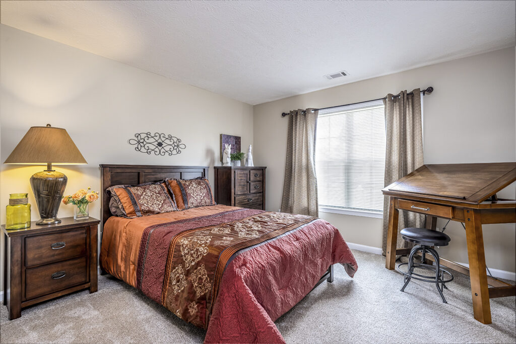 Large second bedroom featuring soft carpeting and a big window that brings in plenty of natural light at The Hammocks at Orchard Park. Perfect for creating a comfortable and inviting space.