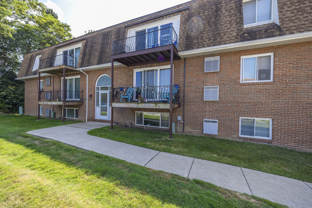 Exterior view of Royal Villa Apartments in Erie, PA, featuring a classic brick facade, private balconies, and controlled building entrances.