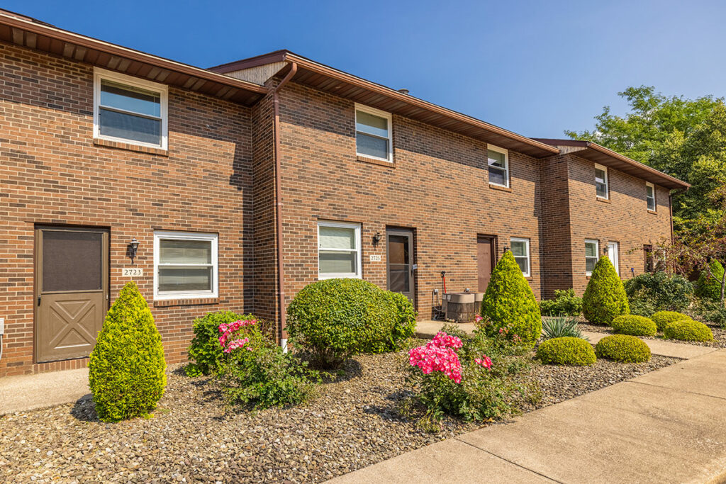 The townhomes at Willowood Village in Erie, PA, featuring attractive brick exteriors, private entrances, and beautifully landscaped surroundings. This view highlights the inviting and well-maintained environment of these rental homes.