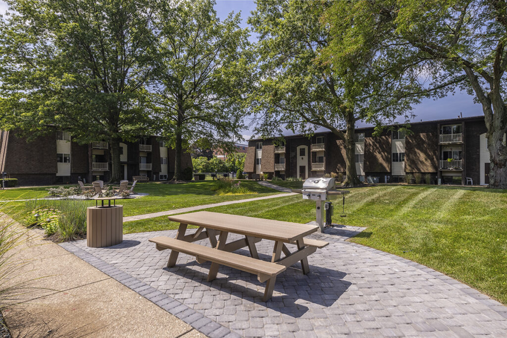 Brand new picnic table and BBQ area located in the courtyard, set on a stone concrete pad with trash cans that blend seamlessly into the natural landscaping.