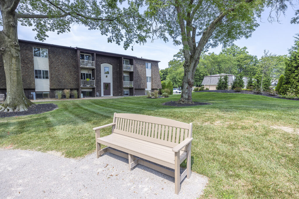 Charming bench located in the courtyard, surrounded by beautifully groomed landscaping, providing a peaceful and inviting outdoor seating area.