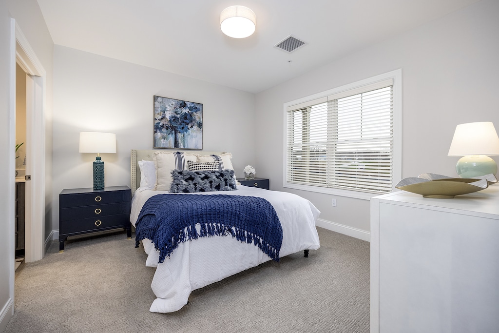Spacious master bedroom flooded with natural light, offering a serene and inviting atmosphere for apartment residents.