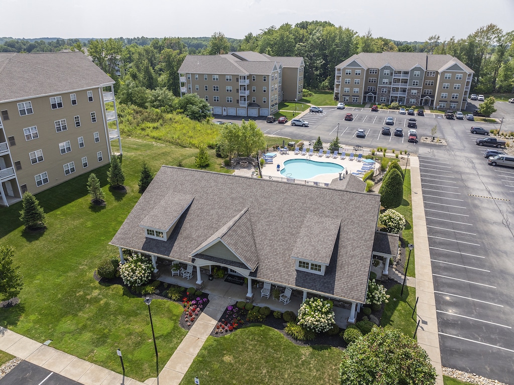 Aerial view of the Hammocks at Millcreek with several buildings, a swimming pool, and a landscaped entrance, surrounded by parking lots and green spaces.