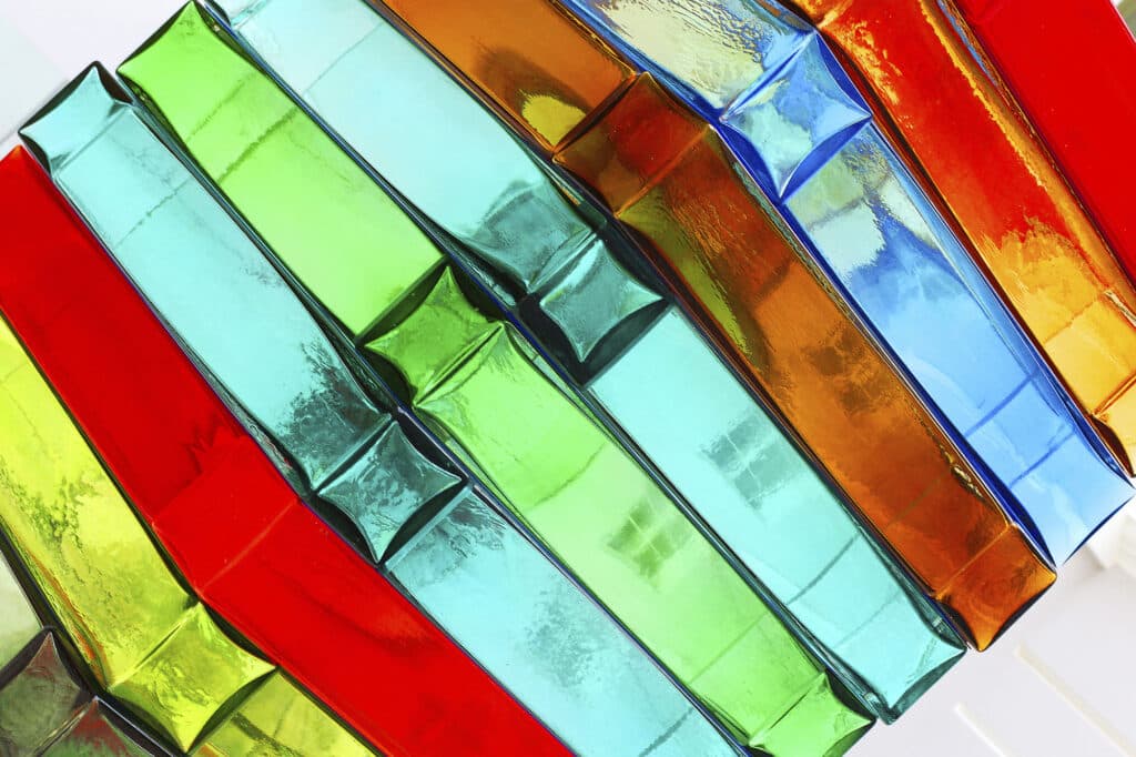 Colorful glass blocks arranged in a diagonal pattern, featuring shades of red, green, blue, and orange.