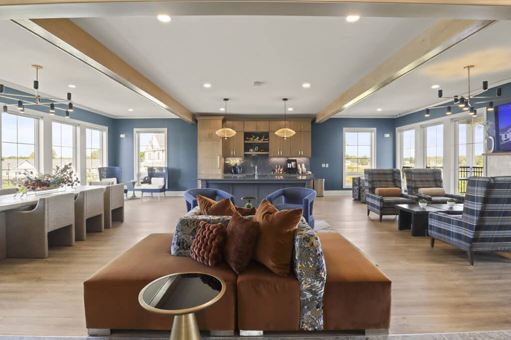 Spacious 24-hour resident lounge at The Hammocks at Fairview, featuring comfortable modern seating, café-style tables, open-concept design, and large windows overlooking the community.