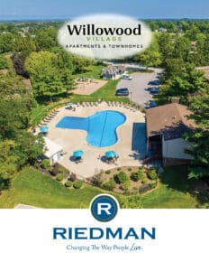 Aerial view of Willowood Village apartments showing outdoor pool, lounge chairs, green spaces, and parking area, with Riedman logo and slogan at the bottom.