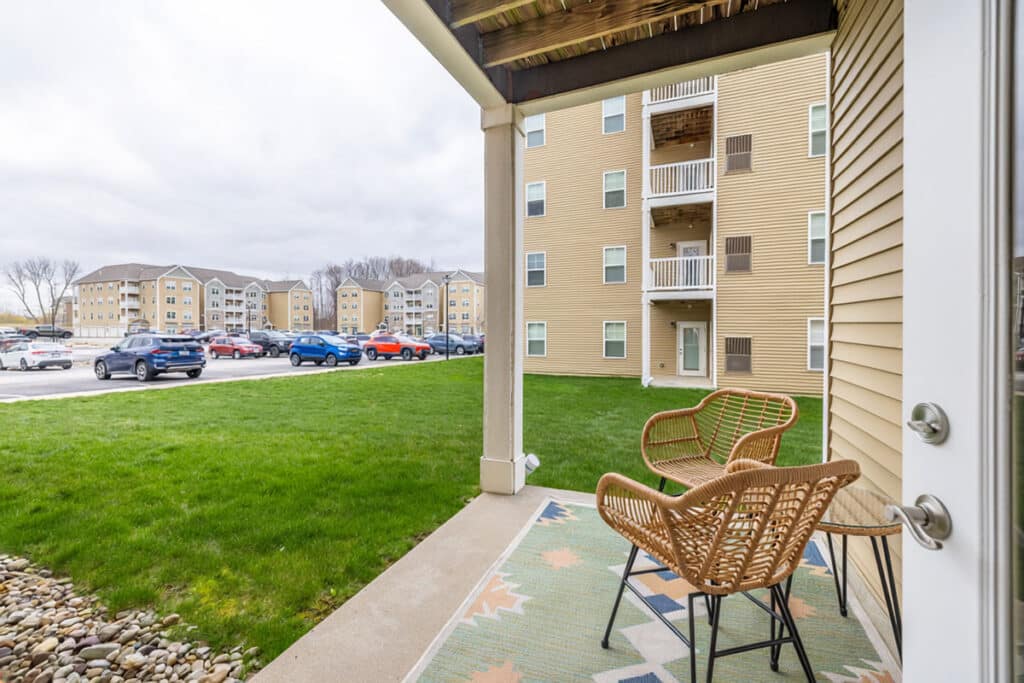 Private ground-level patio with outdoor seating and views of the apartment community at The Hammocks at Millcreek in Erie, PA