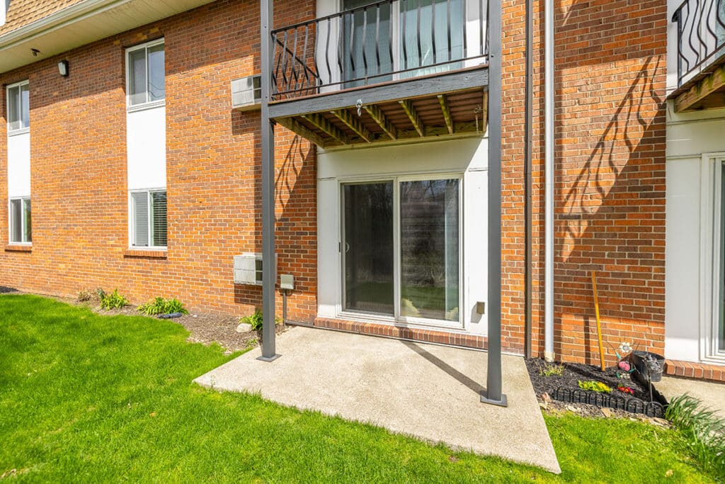 Private ground-level patio at Royal Villa Apartments in Erie, PA with sliding glass doors and green lawn access.
